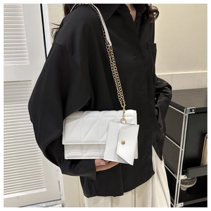Detailansicht der weißen Stepptasche mit goldener Kette und Mini-Umschlagtasche