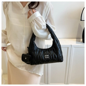 Détail du sac matelassé noir avec texture ondulée brillante et mini pochette amovible