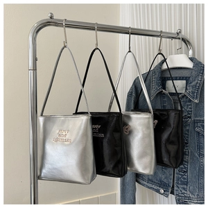Close-up of black and silver glossy leather tote bags with butterfly patterns