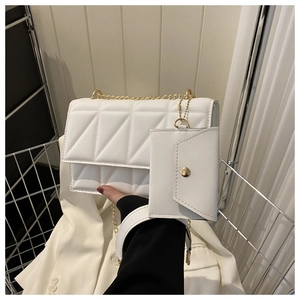 Detail der weißen Stepptasche mit goldener Kette und passendem Mini-Umschlagbeutel