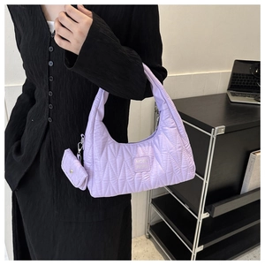 Détail du sac à bandoulière matelassé lilas avec étiquette et mini pochette assortie
