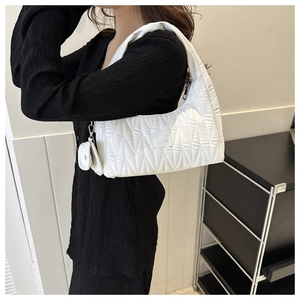 Gros plan du sac bandoulière blanc matelassé avec pochette latérale et logo cousu