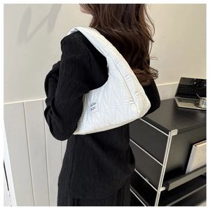 Vue détaillée du sac à bandoulière matelassé blanc avec étiquette et texture