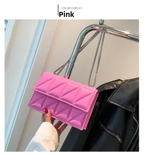 Detailed view of pink quilted crossbody bag with metal chain strap and geometric texture