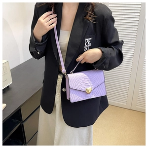 Detail of purple faux snakeskin bag featuring a gold heart-shaped metal twist lock