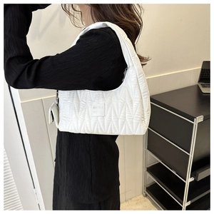 Détail du sac à épaule matelassé blanc avec mini pochette et texture de marque