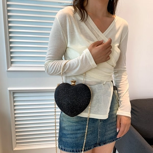 Sparkling black heart-shaped handbag with golden metal handle and fine chain strap