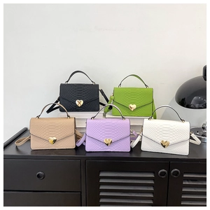 Detail of five embossed faux snakeskin crossbody bags with heart-shaped metal locks