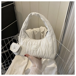 Détail du sac sous le bras en similicuir matelassé blanc avec mini porte-monnaie et logo
