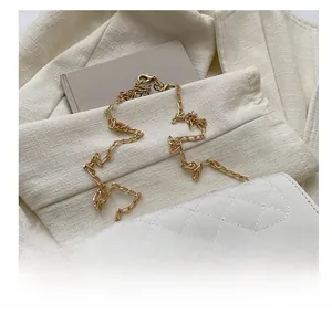 Close-up of white quilted rhombus pattern bag with gold chain strap and metal clasp