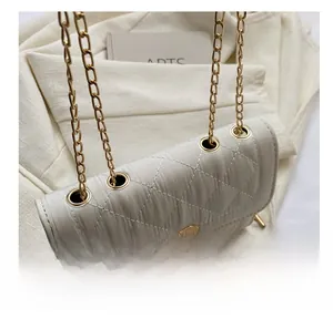 Detailed close-up of gold metal ring eyelets on a white quilted leather shoulder bag