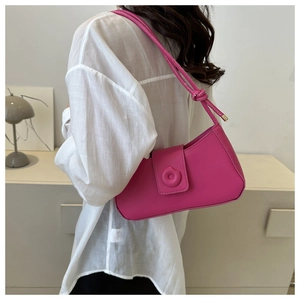 Model view of stylish magenta underarm bag with knot detail and circular buckle