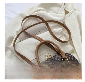 Dettaglio della borsa vintage con motivo monogramma e finiture dorate su giacca blazer