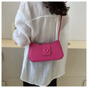 Back view of model wearing a stylish dark pink underarm bag with circular buckle detail