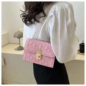 Close-up of pink quilted crossbody bag with gold chain strap and turn-lock closure