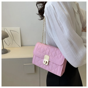 Detail of pink quilted crossbody bag with golden chain strap and swivel lock closure