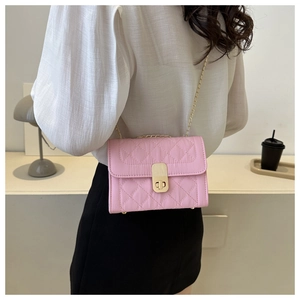 Detail shot of a pink quilted crossbody bag with gold metal chain strap and twist lock