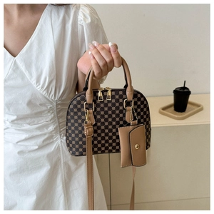 Dettaglio borsa a conchiglia vintage con finiture dorate e mini pochette decorativa