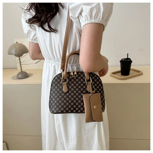 Dettaglio di una borsa a mano vintage a conchiglia con ciondolo portamonete coordinato