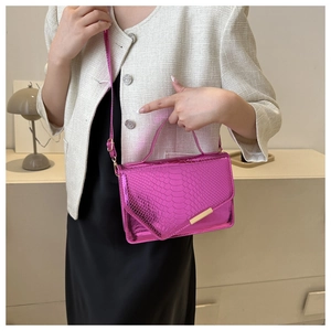 Detail van roze slangenpatroon tas met luxe gouden metalen gesp sluiting