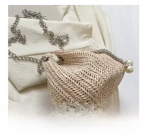 Détail du sac seau en paille avec cordon en perles et bandoulière en chaîne