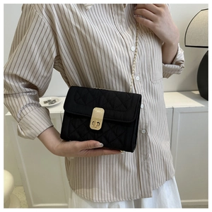 Elegant black quilted crossbody bag with gold chain strap and metallic lock closure