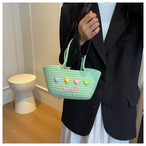 Detail van mintgroene gebreide tas met kleurrijke hartjes en Beautiful-borduurwerk
