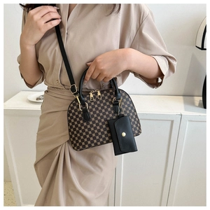 Dettaglio di una borsa a mano marrone con trama geometrica e piccolo astuccio nero