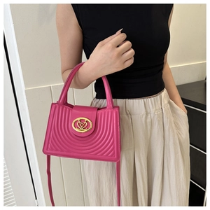 Fuchsia gewatteerde crossbodytas met gouden V-logo gesp getoond op model