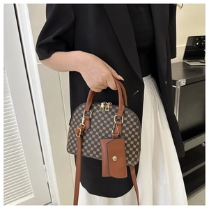Dettaglio della borsa a cupola vintage con motivo geometrico, doppi manici e mini bustina