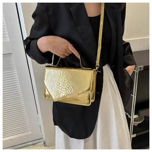 Gouden crossbodytas met krokodillenpatroon gestyled met een formeel pak