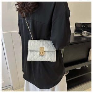 Detailed view of quilted leather texture and golden metal lock on the chain shoulder bag