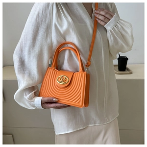 Fel oranje geplooide crossbodytas met gewatteerde patronen en gouden ronde gesp detail