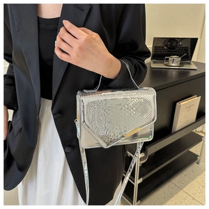 Detail van zilveren crossbodytas met krokodillenpatroon en glanzende metallic afwerking