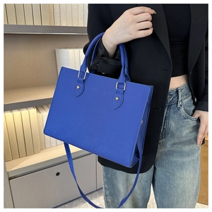 Detail of royal blue Saffiano leather tote bag with gold studs and detachable strap