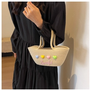 Detail van beige gevlochten tas met kleurrijke 3D-harten en Beautiful borduursel