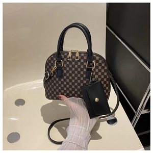 Dettaglio della borsa a conchiglia vintage con motivi geometrici e finiture dorate lisce