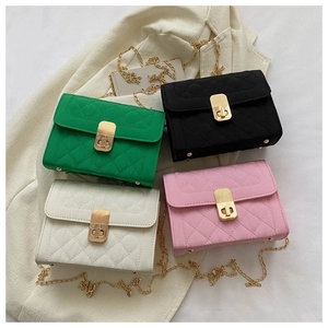 Flat lay of quilted crossbody bags in green, black, white, and pink with chain straps