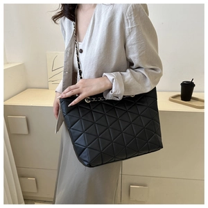 Detailed close-up of triangular quilted pattern on premium black faux leather tote bag