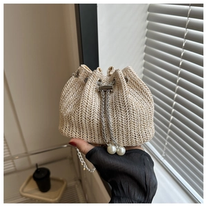 Détail du sac seau en paille avec cordon argenté et décorations en perles blanches