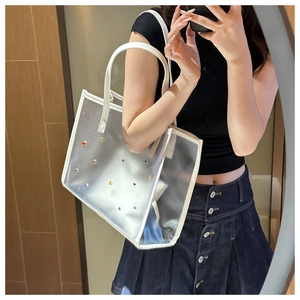 Lifestyle shot of large transparent PVC tote bag with colorful rhinestones and PU handles