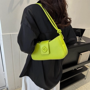 Neon green crescent shoulder bag with round magnetic buckle and knotted strap detail