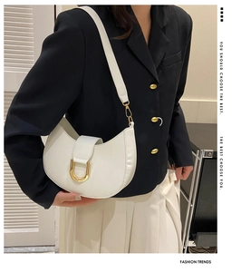 White crescent shoulder bag featuring a prominent gold U-shaped hardware buckle detail