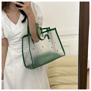 Detail of green PVC transparent tote bag with colorful studs and matching inner pouch