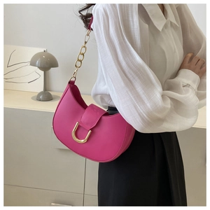Rose pink half-moon underarm bag with gold chain and metal buckle on a model