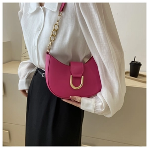 Detail of rose pink crescent bag with golden D-ring buckle and elegant chain strap