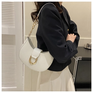 Detail of white half-moon hobo bag with gold horseshoe buckle and chain strap on model