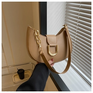 Detail of khaki crescent bag with gold U-shaped buckle and elegant metal chain strap