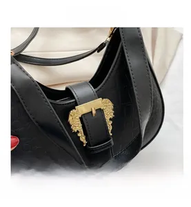 Detail of black crocodile pattern leather bag with vintage golden metallic buckle