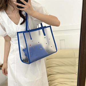 Transparent jelly tote bag with colorful rivets and blue leather trim including inner pouch